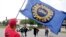 Members of the United Auto Worker Union walk out of the Chicago Ford Assembly Plant as Lance Williams from Lansing, Ill., waves the UAW flag Sept. 29, 2023, in Chicago.