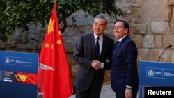 Spain's Foreign Minister Jose Manuel Albares, right, and China's Foreign Minister Wang Yi shake hands after a press conference following their meeting at Cordoba's Alcazar fortress, Spain, Feb. 18, 2024.