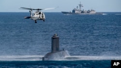 Helikopter, kapal, dan kapal selam angkatan laut Turki mengikuti latihan perang di lepas pantai Catania, Sisilia, Italia selatan, Senin, 26 Februari 2024. Latihan tersebut merupakan bagian dari latihan perang NATO 'Dynamic Manta 24'. (AP/Salvatore Cavalli)