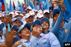 Hun Manet, Panglima Angkatan Darat Kerajaan Kamboja dan putra sulung Perdana Menteri Hun Sen, berswafoto dengan para pendukungnya saat kampanye di Phnom Penh, 21Juli 2023. (TANG CHHIN SOTHY / AFP)