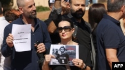 A woman holds a portrait of video journalist Issam Abdallah, killed Oct. 13 by strikes on the village of Alma al-Shaab in southern Lebanon while he and others were covering cross-border shelling, during a protest in Beirut, Lebanon, Oct. 15, 2023.