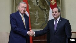 Le président turc Recep Tayyip Erdogan (à gauche) serrant la main de son homologue égyptien Abdel Fattah al-Sisi (à droite) lors d'une visite officielle en Égypte le 14 février 2024. (Photo by TURKISH PRESIDENTIAL PRESS SERVICE / AFP) 