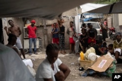 FILE - People displaced by gang violence gather to seek refuge, in Port-au-Prince, Haiti, June 2, 2023.