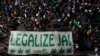 Manifestantes sostienen una manta que dice en portugués, "Legalícenla ya", en una marcha para exigir la legalización de la marihuana, en Sao Paulo, el domingo 16 de junio de 2024. 