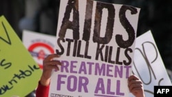 FILE - A man holds a placard as hundreds of AIDS activists march through the streets of Durban, South Africa during the 21st International Aids Conference on July 18, 2016. 