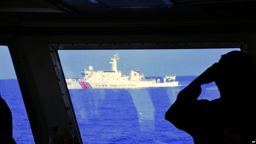 DOSYA - Filipin Sahil Güvenlik tarafından sağlanan bu fotoğrafta, bir Çin Sahil Güvenlik gemisi, 2 Mart 2022'de Scarborough Shoal'da devriye gezerken bir Filipin Sahil Güvenlik gemisinin yakınında seyrediyor.