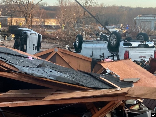 FILE - Upturned vehicles are seen next to damaged structures after a tornado swept through Coralville, Iowa, March 31, 2023.