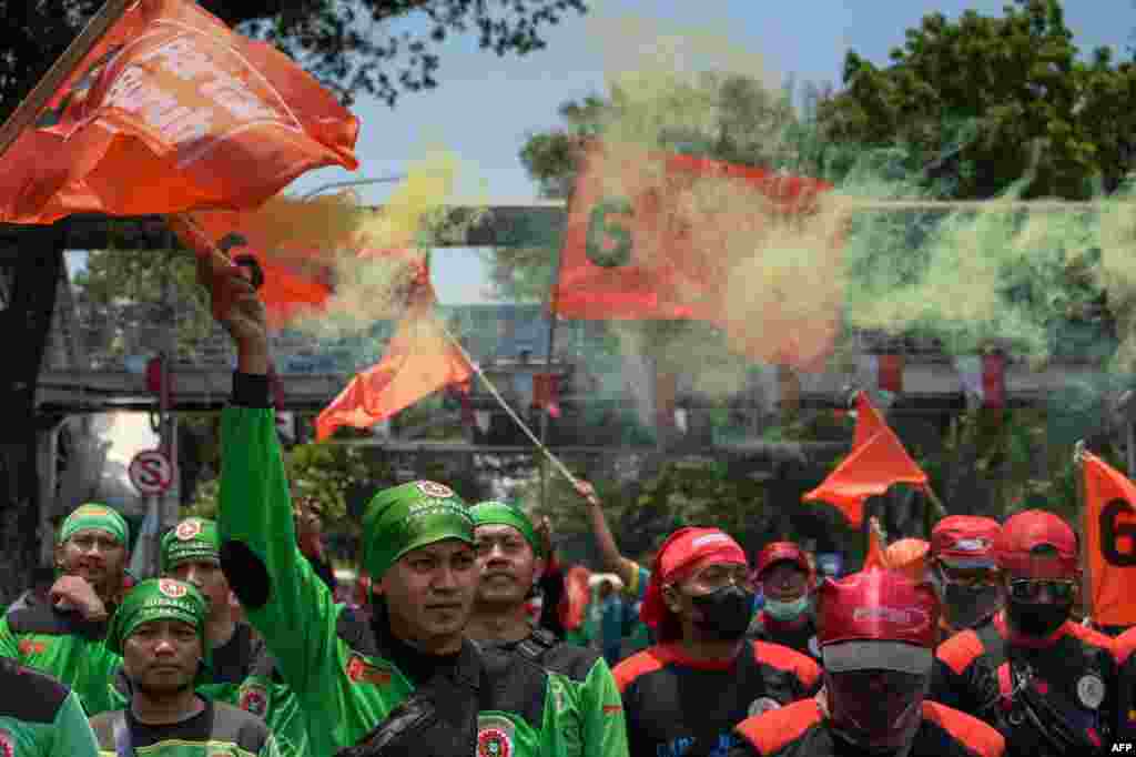 Workers take part in a protest, directed at Indonesia's President Joko Widodo, to demand the government reduce the price of basic commodities and increase the 2024 minimum wage by 15 percent, in Jakarta.