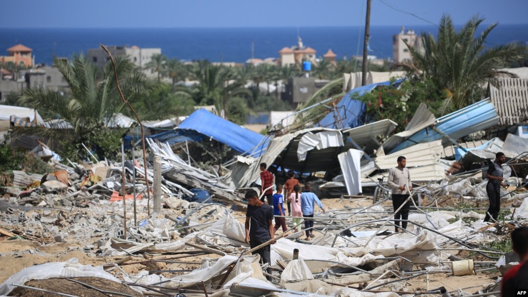 People look for salvageable items following an Israeli raid in al-Mawasi area of Rafah on the southern Gaza Strip, June 29, 2024.