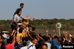 Aid is distributed while Palestinians fleeing north Gaza move southward as Israeli tanks roll deeper into the enclave, amid the ongoing conflict between Israel and Hamas, in the central Gaza Strip, Nov. 10, 2023.