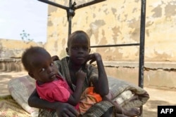 FILE—Displaced children who fled the ongoing violence by two rival Sudanese generals, rest on a bed in the courtyard of the university of Al-Jazira, transformed into a makeshift shelter, in al-Hasahisa south of Khartoum on July 8, 2023.