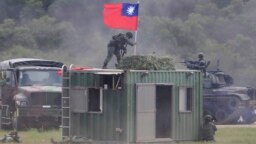 Seorang tentara memegang bendera nasional Taiwan selama latihan simulasi pertempuran darat dan udara terpadu di Kabupaten Hsinchu, Taiwan utara, Kamis, 21 September 2023. (AP/Chiang Ying-ying)