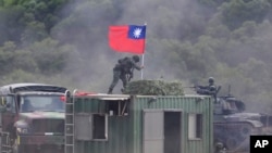 资料照片：台湾士兵在台湾北部新竹县一个军事演习中扶着台湾旗帜。（2023年9月21日）