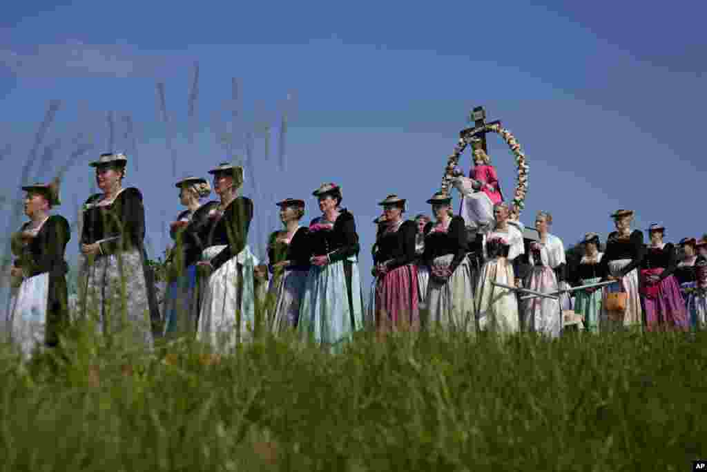 Bavarian women in their traditional costumes carry figures of Virgin Mary during a festive Corpus Christi procession in Wackersberg near Bad Toelz, southern Germany.