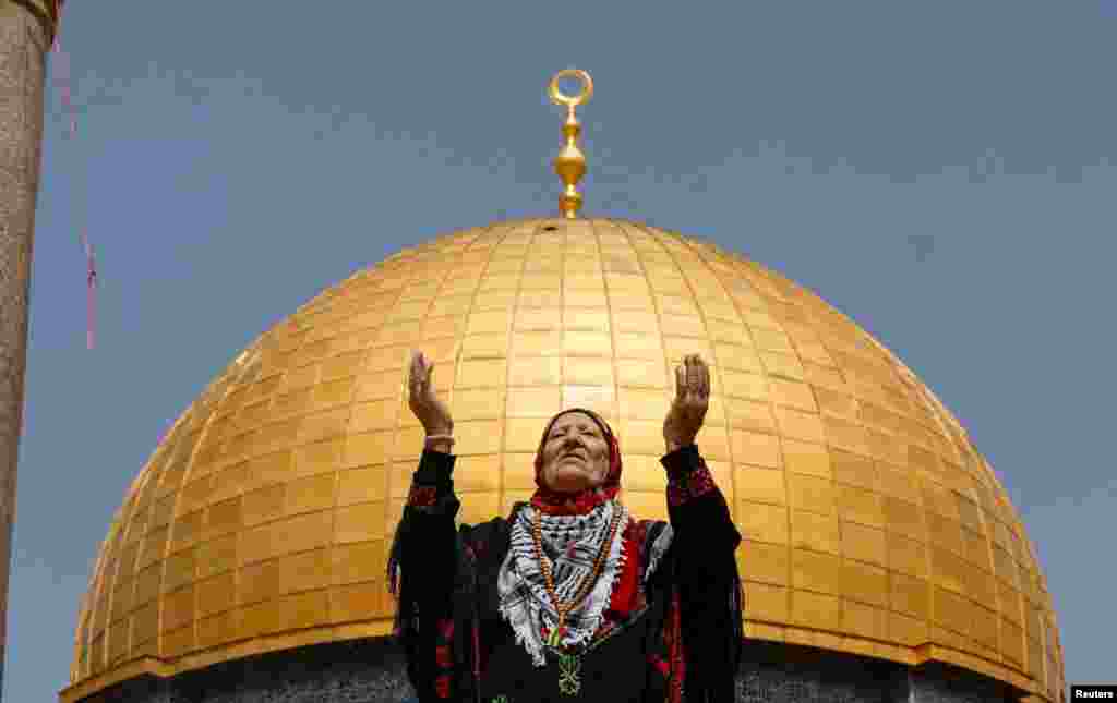 A woman prays as Palestinian Muslims attend Friday prayers of the Muslim holy month of Ramadan, on the compound known to Muslims as the Noble Sanctuary and to Jews as the Temple Mount, in Jerusalem's Old City.