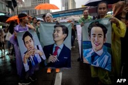 Pengunjuk rasa pro-demokrasi membawa foto pemimpin Partai Maju Pita Limjaroenrat dalam aksi demo di Bangkok, 23 Juli 2023, setelah parlemen Thailand memblokir pencalonan perdana menteri dari pemimpin partai Pita Limjaroenrat. (Jack TAYLOR / AFP)