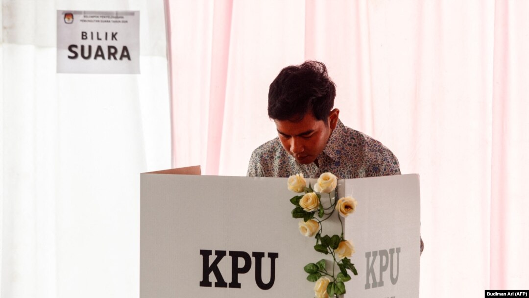 Calon wakil presiden Gibran Rakabuming Raka di dalam bilik suara dalam Pilpres dan Pileg 2024 di Surakarta, Jawa Tengah, 14 Februari 2024. (Foto: Budiman Ari/AFP)