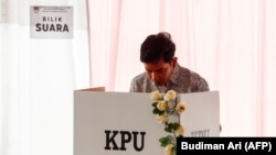 Calon wakil presiden Gibran Rakabuming Raka di dalam bilik suara dalam Pilpres dan Pileg 2024 di Surakarta, Jawa Tengah, 14 Februari 2024. (Foto: Budiman Ari/AFP)