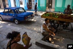 People sit in the shade in Havana, Cuba, July 5, 2023. The entire planet sweltered for the two unofficial hottest days in human record keeping Monday and Tuesday, according to University of Maine scientists at the Climate Reanalyzer project.