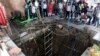 People stand around a structure built over an old temple well that collapsed as a large crowd of devotees gathered for the Ram Navami Hindu festival in Indore, India, March 30, 2023.