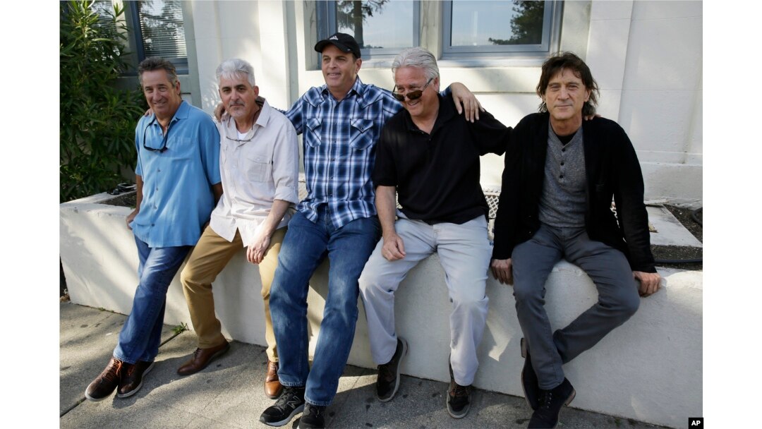 FILE - The Waldos, from left, Mark Gravitch, Larry Schwartz, Dave Reddix, Jeffrey Noel and Steve Capper sit on a wall they used to frequent at San Rafael High School in San Rafael, California, April 13, 2018.
