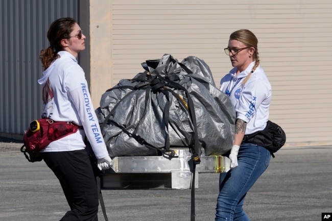 FILE - Recovery team members carry a capsule containing NASA's first asteroid samples to a temporary clean room at Dugway Proving Ground in Utah on Sunday, Sept. 24, 2023. (AP Photo/Rick Bowmer, Pool)