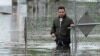 Francisco Lopez stands near the flooded parking lot of his apartment building, June 13, 2024, in Hallandale, Fla. 