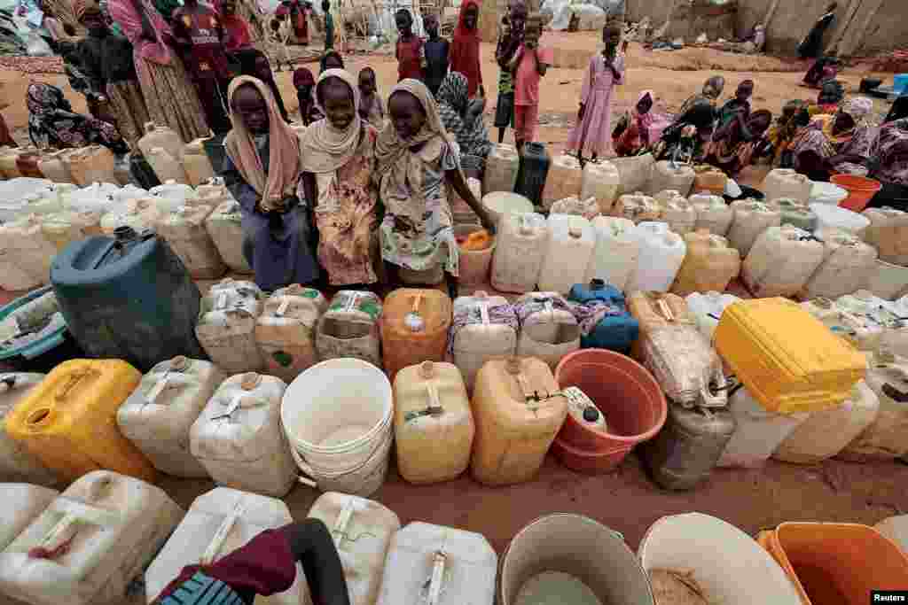 Sudanese girls who fled the conflict in Geneina, in Sudan's Darfur region, line up at the water point in Adre, Chad, July 30, 2023.