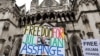 A demonstrator holds a placard reading "Freedom for Julian Assange" during a protest outside of the Royal Courts of Justice, Britain's High Court in central London, Feb. 21, 2024.