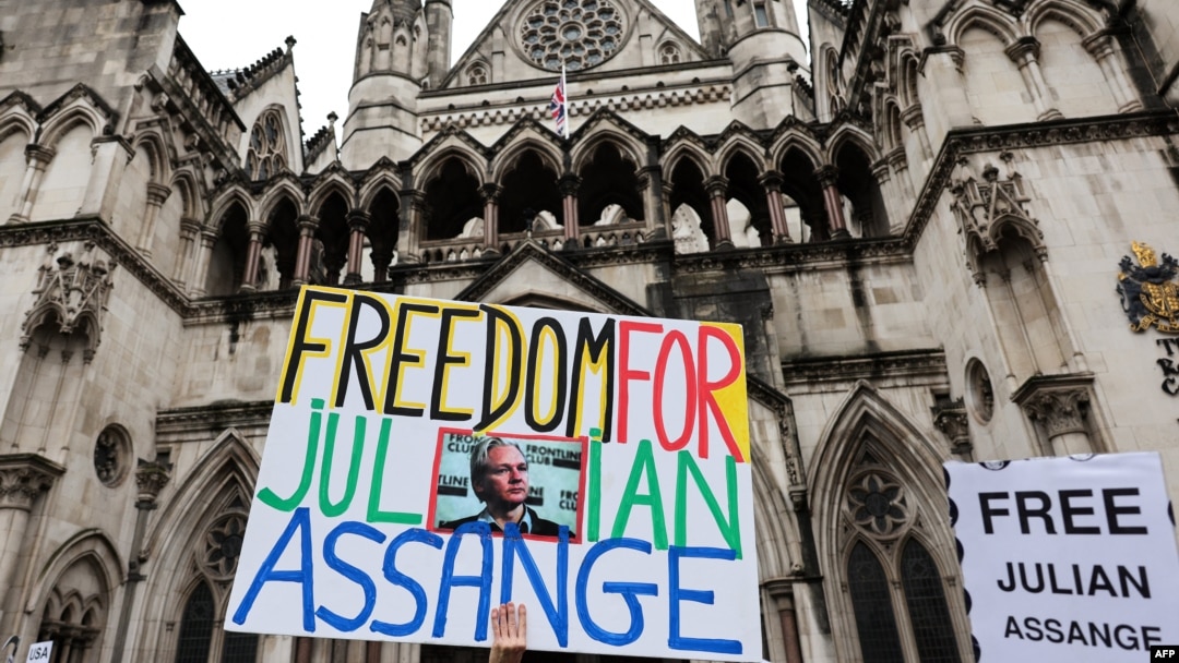 A demonstrator holds a placard reading "Freedom for Julian Assange" during a protest outside of the Royal Courts of Justice, Britain's High Court in central London, Feb. 21, 2024.
