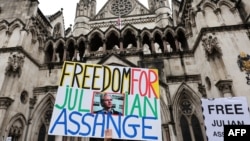 A demonstrator holds a placard reading "Freedom for Julian Assange" during a protest outside of the Royal Courts of Justice, Britain's High Court in central London, Feb. 21, 2024.
