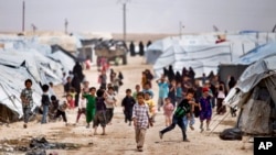 FILE - Children gather outside their tents at the al-Hol camp, which houses families of members of the Islamic State group, in Hasakeh province, Syria, May 1, 2021.