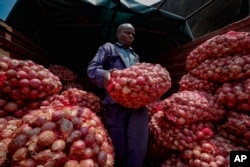 Timothy Kinyua unloads sacks of onions from Ethiopia at an open market in Nairobi, Kenya, Sept. 12, 2023.