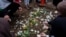 FILE - Mourners place flowers at the grave of Wadea Al-Fayoume, 6, at Parkholm Cemetery in LaGrange, Illinois, Oct. 16, 2023.