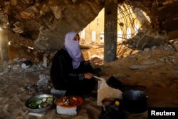 A woman cooks, amid shortages of food supplies and fuel, as the conflict between Israel and Palestinian Islamist group Hamas continues, in Khan Younis in the southern Gaza Strip, Nov. 17, 2023.