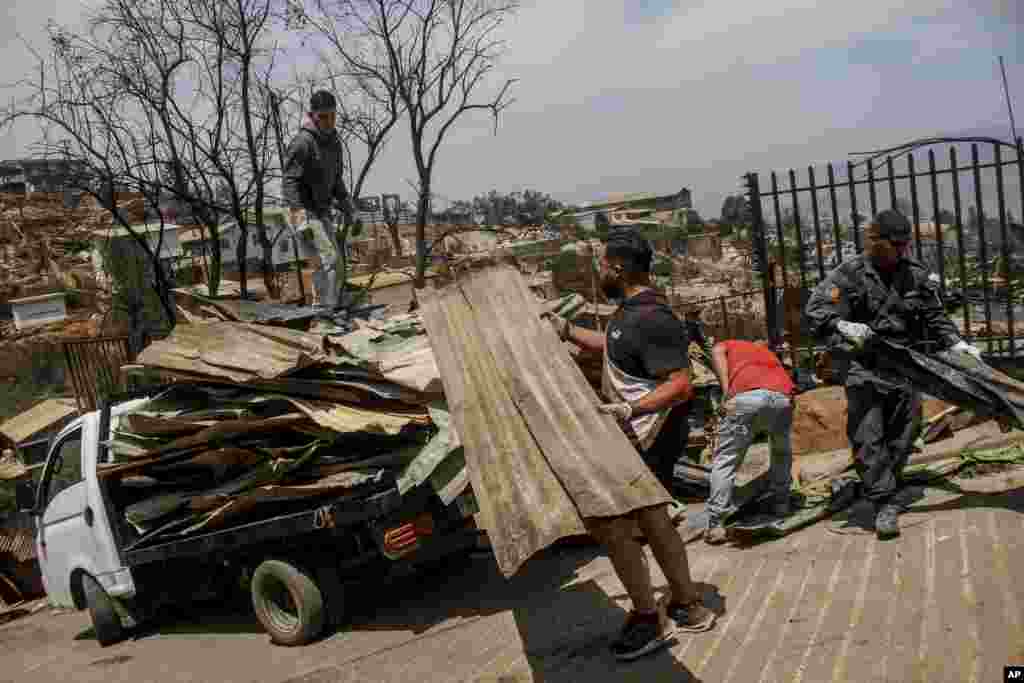 Lugareños limpian los escombros de las casas quemadas luego de que su vecindario fuera afectado por el fuego en Viña del Mar.