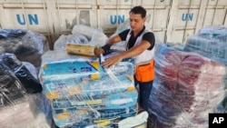 A Red Crescent worker prepares aid for distribution to Palestinians as Red Crescent and United Nations staff work at a UNRWA warehouse in Deir Al-Balah, Gaza Strip, on Oct. 23, 2023.