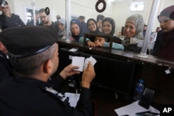Warga Palestina yang memiliki dwi kewarganegaraan mendaftar untuk menyeberang ke Mesir, di loket pendaftaran di Jalur Gaza, Kamis, 2 November 2023. (Foto: Hatem Ali/ AP Photo)