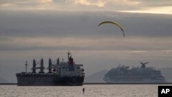 Peselancar layang Robert Rice melakukan hidrofoil di lepas pantai Belmont Shore di Long Beach, California, Minggu, 18 Februari 2024. Ramalan cuaca memperingatkan kemungkinan banjir, hujan es, angin kencang dan bahkan tornado singkat beberapa hari ke depan. (AP/Damian Dovarganes)