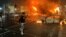 Flames rise from a car and a bus, set alight at the junction of Bachelors Walk and the O'Connell Bridge, in Dublin,  Nov. 23, 2023, as people took to the streets in protest following stabbings earlier in the day.