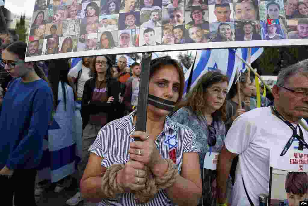 Una mujer con las manos atadas y la boca amordazada participa en la marcha por el regreso de los rehenes en poder de Hamás que hoy concluyó ne Jerusalén, muy cerca de las oficinas del Primer Ministro, Benjamín Netanyahu.