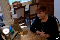 Deanna Dezern, 83 tahun berinteraksi dengan robot ElliQ di rumahnya di Tamarac, Florida (dok: AP/Rebecca Blackwell)