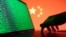 (FILE) A hand is seen on a laptop with binary codes displayed in front of the Chinese flag in this illustration taken, August 19, 2022.