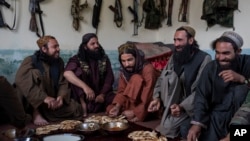 FILE - Taliban fighters enjoy lunch inside a house that is used as a checkpoint in Wardak province, Afghanistan, June 22, 2023. Taliban representatives traveled to Indonesia earlier this month to improve political and economic ties.