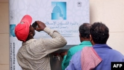 Workers line up in front of a water distributer on a hot summer day in Dubai, July 12, 2023.