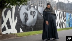 FILE - Asiyah Timimi, whose husband was stabbed to death in January 2021, stands along the murals on Metropolitan Branch Trail on Oct. 27, 2023 in Washington.