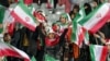 FILE - Female football fans wave Iranian national flags during the friendly football match between Iran and Russia at Azadi Stadium in Tehran, on March 23, 2023. The head of the Iranian Football Federation has renewed a vow to allow women into various stadiums in the country. 