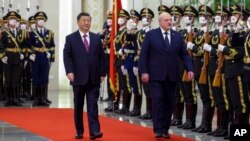 Visiting Belarusian President Alexander Lukashenko and Chinese President Xi Jinping review an honor guard during a welcome ceremony at the Great Hall of the People in Beijing, March 1, 2023. (Xinhua via AP)