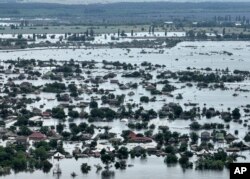FILE - Houses are seen underwater in the flooded town of Oleshky, Ukraine, Saturday, June 10, 2023.