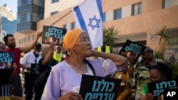 Members of the African Hebrew Israelites of Jerusalem rally outside of the District Court in Beersheba, Israel, ahead of a hearing on the deportation orders for dozens from their community, July 19, 2023.